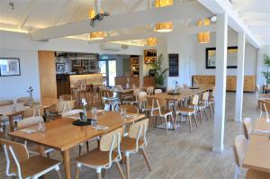 a dining room with wooden tables and chairs at Villa Topaz at Palm Beach by Waiheke Unlimited in Palm Beach