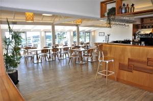 a restaurant with tables and chairs and a bar at Villa Topaz at Palm Beach by Waiheke Unlimited in Palm Beach +8 photos