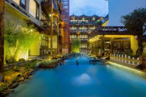 a large swimming pool in a courtyard of a building at Old Story Inn Lijiang Old Town in Lijiang