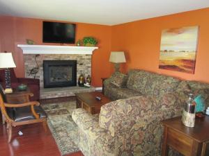 a living room with a couch and a fireplace at Byrncliff Maple Lodge in Varysburg