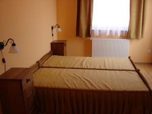 A bed or beds in a room at Horváth Vendégház