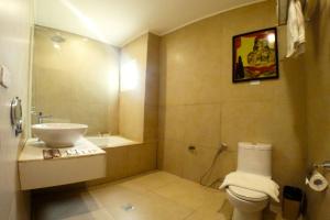 a bathroom with a white toilet and a sink at Palm Grass Hotel in Cebu City