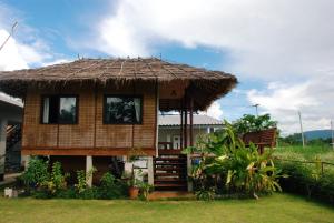 une petite maison avec un toit de paille dans l'établissement Pak Ping Ing Jai, à Ban Mai