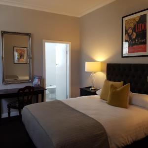 a bedroom with a bed and a mirror and a desk at Northern Star Hotel in Hamilton
