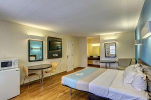 1 dormitorio con 1 cama, mesa y sillas en Motel 6-Dickson, TN, en Dickson