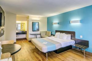a hotel room with a large bed and a table at Motel 6-Dickson, TN in Dickson