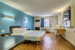 a hotel room with a large bed and a desk at Motel 6-Dickson, TN in Dickson