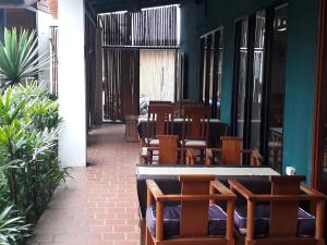 a dining room with wooden chairs and tables at Charming Lao Hotel in Ban Chéng