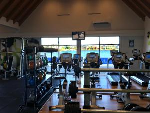 un gimnasio con muchas cintas de correr y pesas en King House, en Point Cook