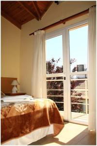 a bedroom with a bed and a large window at Complejo Andalhue in Puerto Madryn