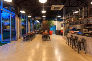 a restaurant with tables and chairs and a bar at Tamali Hotel in Nakhon Si Thammarat