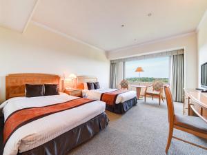 ein Hotelzimmer mit 2 Betten und einem Schreibtisch in der Unterkunft Forest Inn Showakan (Okura Hotels & Resorts) in Akishima