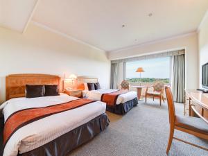 a hotel room with two beds and a desk at Forest Inn Showakan (Okura Hotels & Resorts) in Akishima