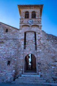 um edifício de tijolos com uma torre de relógio em Hotel Assisivm Antica Dimora AD em Assisi