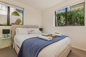 a bedroom with a bed with towels on it at 110 Hampden Apartments in Hobart