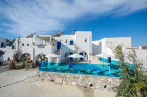 Un gran edificio blanco con una piscina enfrente. en Studios Sofia Dream, en Agia Anna de Naxos