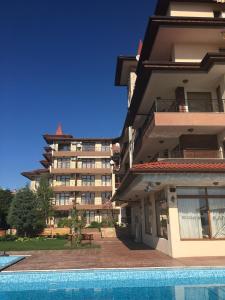 a building with a swimming pool in front of a building at Rich-3 SP apartments in Ravda