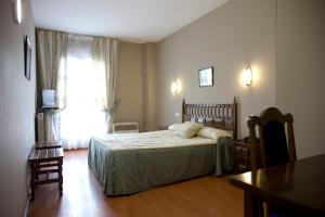 1 dormitorio con cama, mesa y ventana en Hotel Casa Aurelia, en Villaralbo