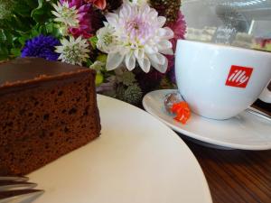 un trozo de pastel y una taza de café en Centrale Hotel und Restaurant, en Waldkraiburg
