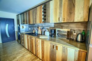 a kitchen with wooden cabinets and a counter top at Guest House Villa Bozhenitsa in Bozhenitsa