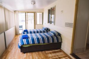 a bedroom with two beds with blue pillows on it at Port Gregory Caravan Park in Gregory