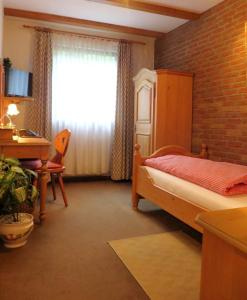 a bedroom with a bed and a desk and a window at Hotel Gastgeb in Essen