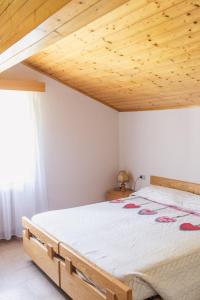 una camera con un grande letto e un soffitto in legno di Hotel Mignon a Folgaria
