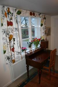 HovaにあるFagerlid Gårdのピアノ付きの部屋、花の窓