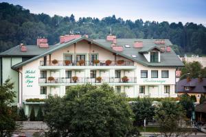 duży biały budynek z kwiatami na balkonach w obiekcie Hotel i Restauracja Bona w mieście Sanok