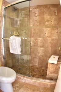 a bathroom with a shower with a toilet and a sink at Gulfcoast Inn Naples in Naples