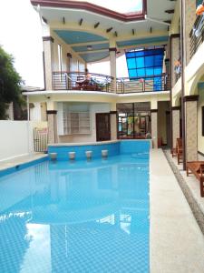 a swimming pool in a building with a house at Mariner's Pension House in Puerto Princesa City