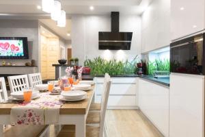 une cuisine avec une table en bois et une salle à manger dans l'établissement Apartament PAJO II -Rezydencja Tatry--GROTA SOLNA--BALKON--PARKING, à Zakopane