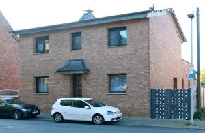 a white car parked in front of a brick house at Ferienwohnung Yvonne in Oberhausen