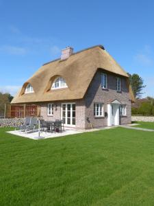 a large brick house with a thatched roof at Heidehüs Seepferdchen in Nebel