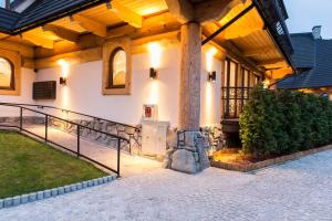 a large building with a porch with a pillar at Apartament PAJO II REZYDENCJA TATRY in Zakopane