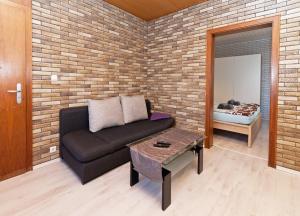a living room with a couch and a brick wall at Ferienwohnung Yvonne in Oberhausen +2 photos