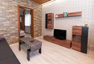 a living room with a tv and a brick wall at Ferienwohnung Yvonne in Oberhausen