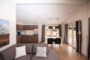 a living room with a couch and a kitchen at Hoeve Springendal Erf&Bron in Hezingen +56 photos