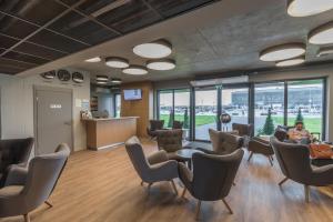 a room with chairs and a person sitting in a waiting room at Air Hotel in Karmėlava
