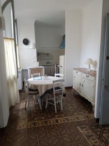 Ca di Ni في فينالي ليغوري: مطبخ مع طاولة وكراسي في غرفة