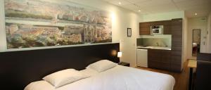 a bedroom with a white bed and a painting on the wall at Quadraverde in Lyon