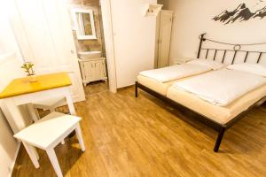 a room with a bed, chair, and table in it at Hostel Hildegarden in Tolmin
