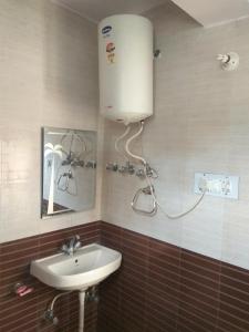 a bathroom with a sink and a water tank on the wall at Celebrations Homestay in Shimla
