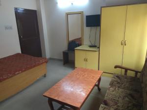 a bedroom with a bed and a table and a cabinet at Celebrations Homestay in Shimla