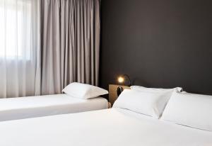 2 Betten nebeneinander in einem Zimmer in der Unterkunft B&B HOTEL Granada in Pulianas