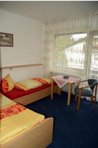 Zimmer mit 2 Betten, einem Tisch und einem Fenster in der Unterkunft Hotel Leise Garni in Willingen