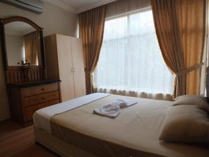 アンタルヤにあるUyar Palaceのベッドルーム1室(鏡付きのベッド1台、窓付)