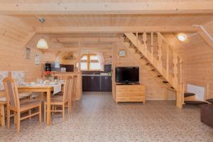ein Esszimmer und eine Küche in einer Blockhütte in der Unterkunft Domki LIDO Wicie in Vitte