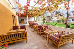 una fila de bancos de madera sentados en un patio en Hostel Hildegarden en Tolmin