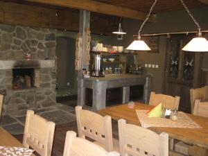 a dining room with a stone fireplace and a table and chairs at Ubytování Elias in Černá v Pošumaví